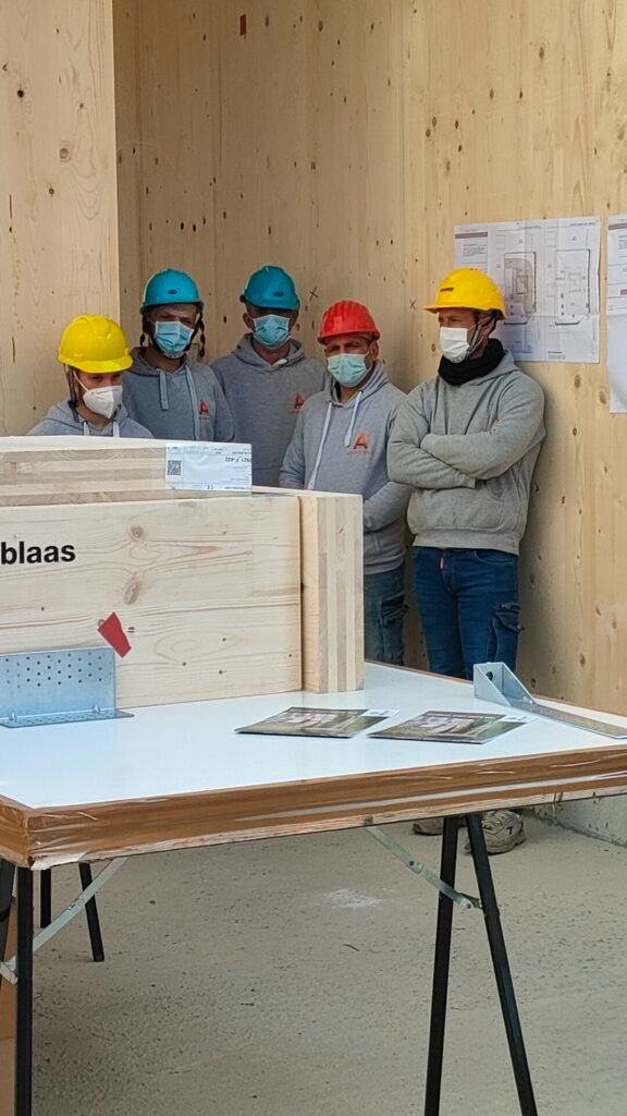 Pannelli XLAM – gruppo di corsisti con caschetto davanti alla parete in legno